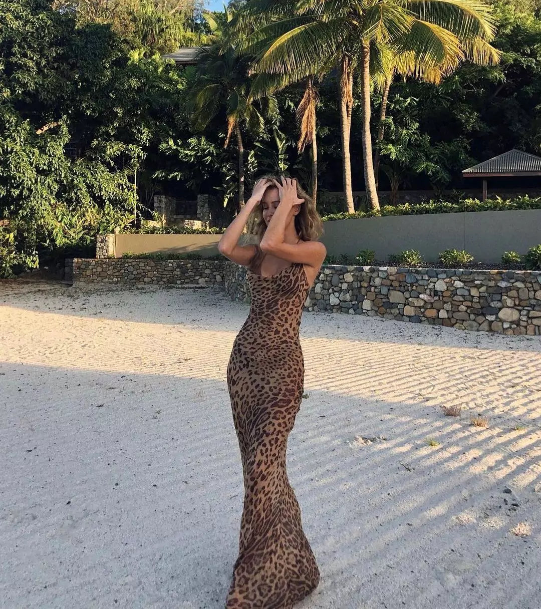 A woman in a leopard print dress standing in a park
