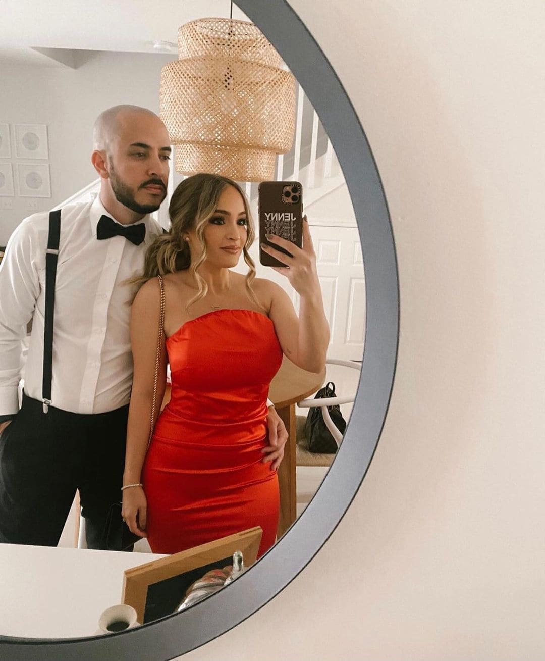 A man and woman taking a selfie in a mirror.