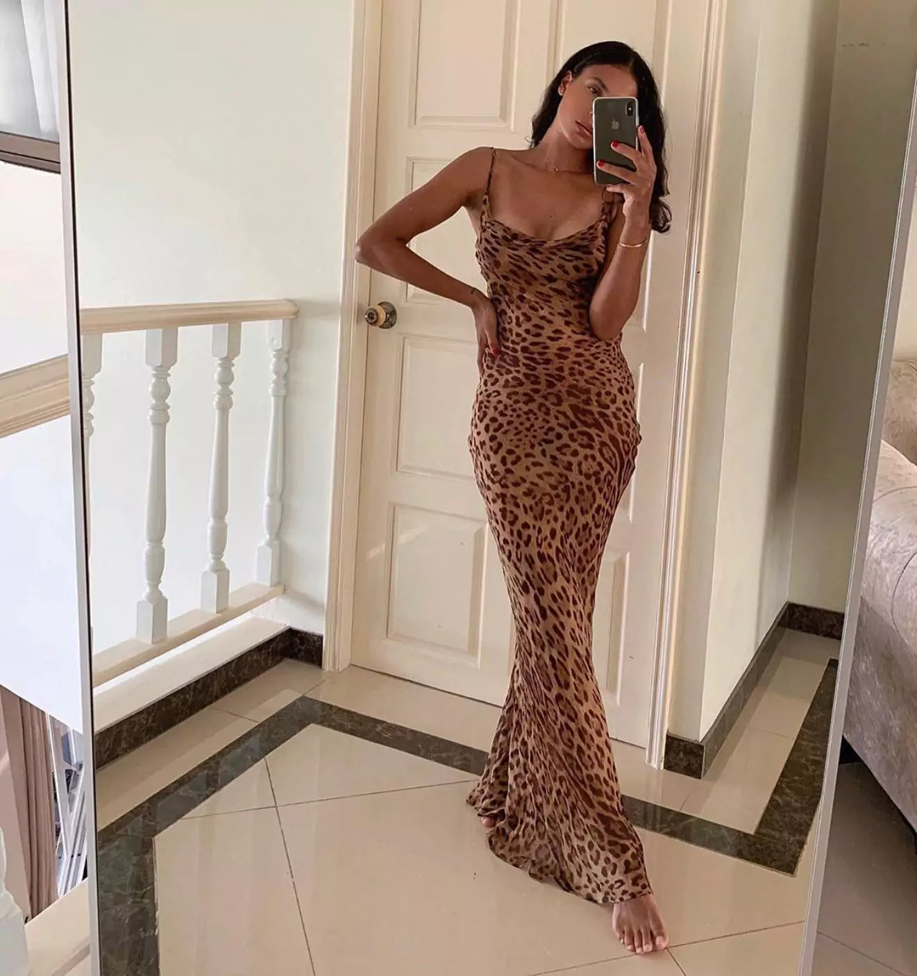 A woman in a leopard print dress standing in a room.