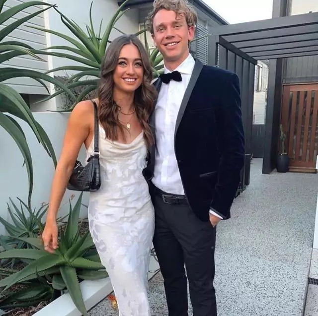 A man and woman standing next to each other in a white dress.