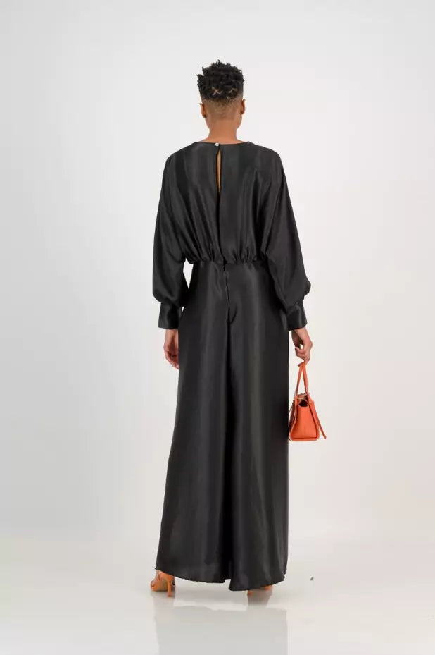 The back view of a woman wearing a black silk dress.