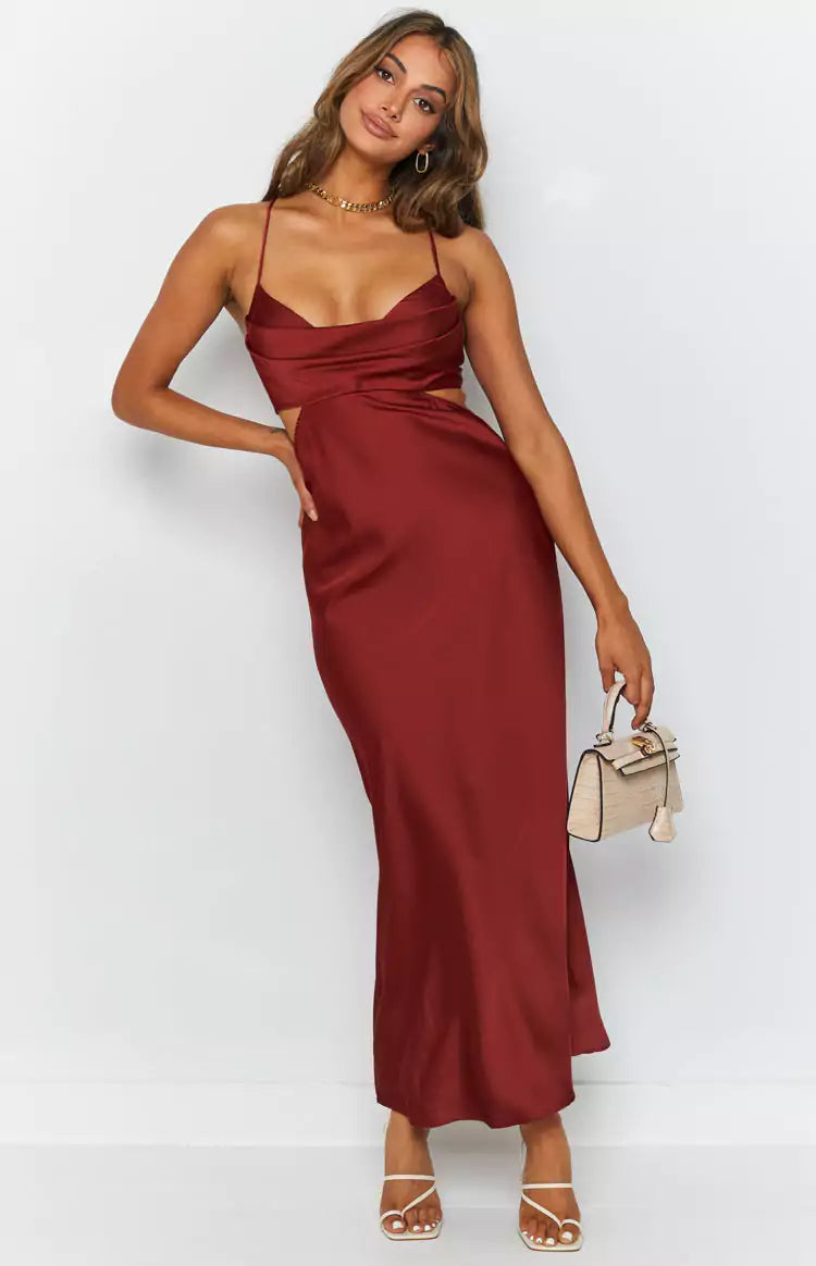The model is wearing a burgundy satin midi dress.