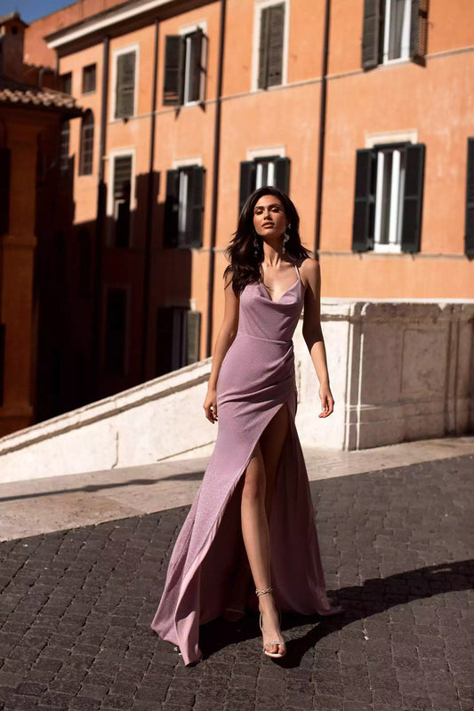 A woman in a lavender dress walking down a cobbled street.