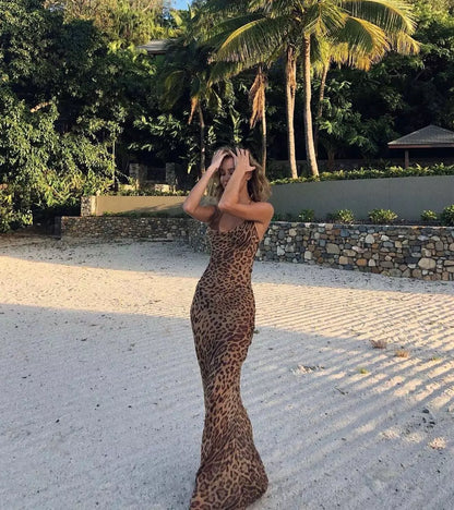 A woman in a leopard print dress standing in a park