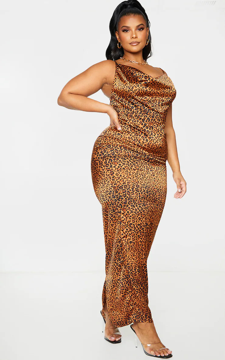 A plus size woman wearing a Kymani leopard print midaxi dress with a cowl neckline. 