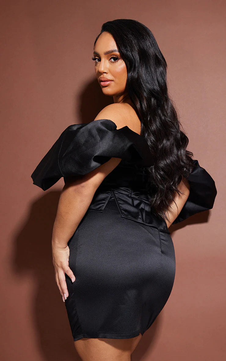 A woman in a black off shoulder mini dress posing.