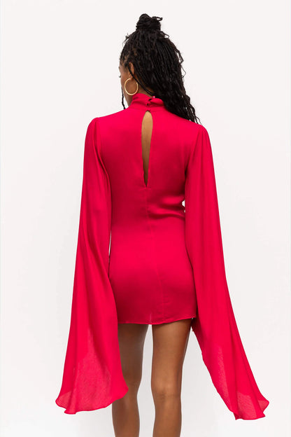 The back view of a woman wearing a pink dress.