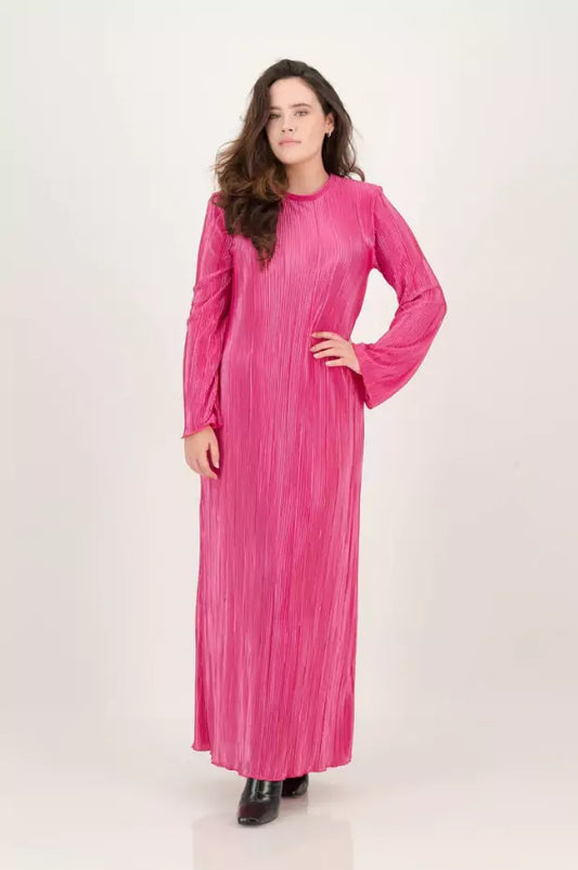 A woman is posing in a pink long sleeved dress.