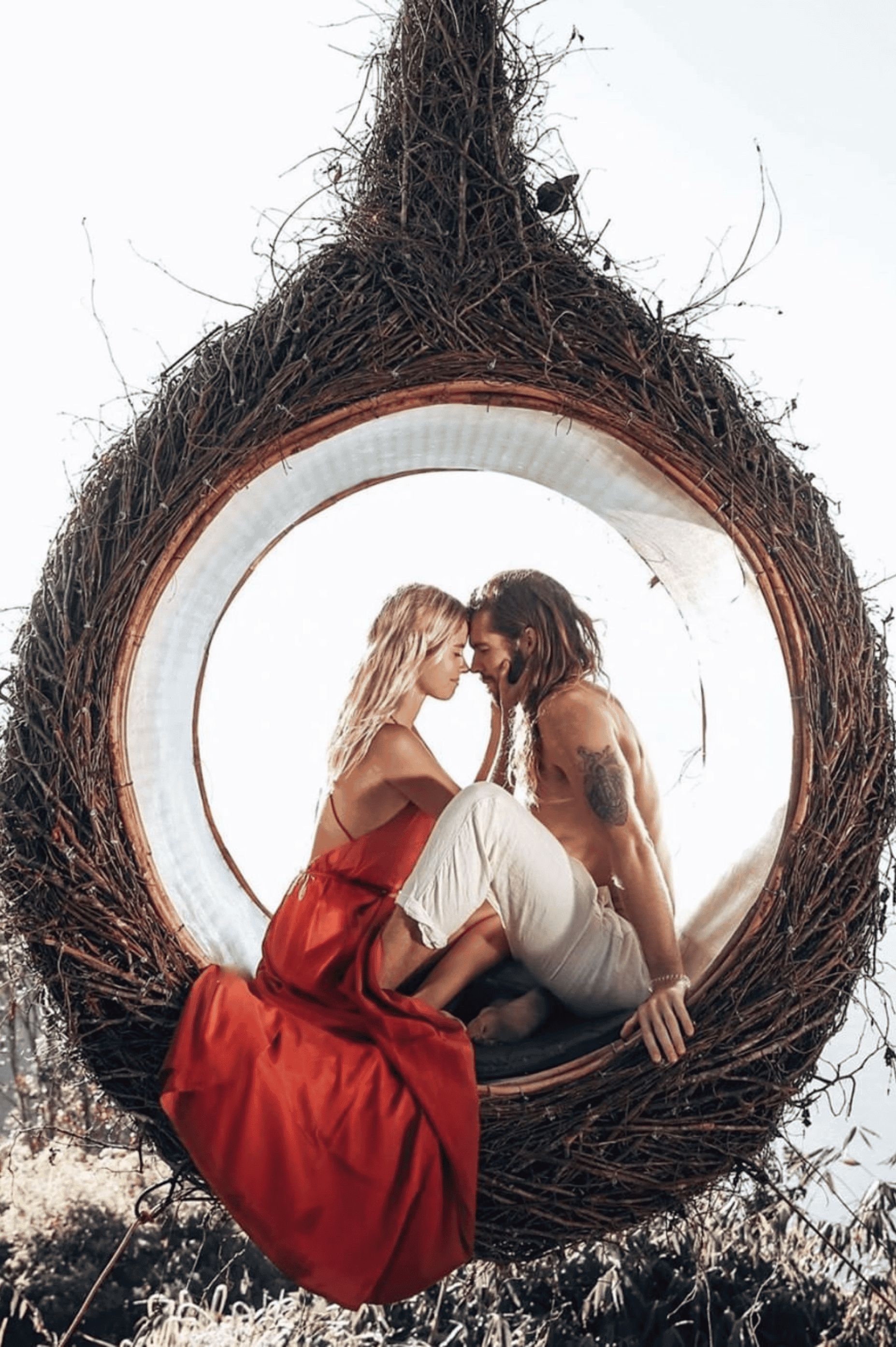 A man and woman sitting in a birdcage.