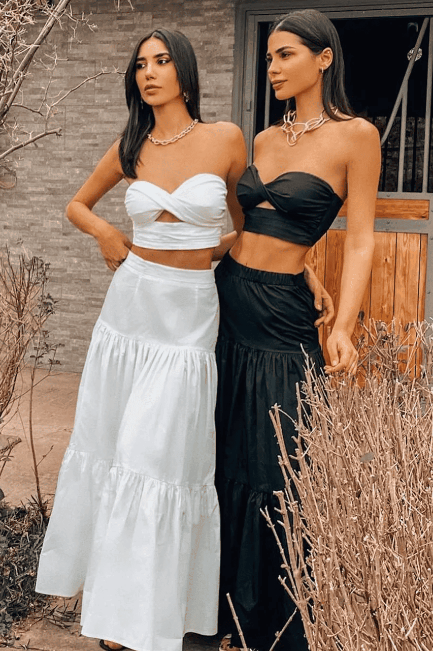 Two women posing in front of a house.