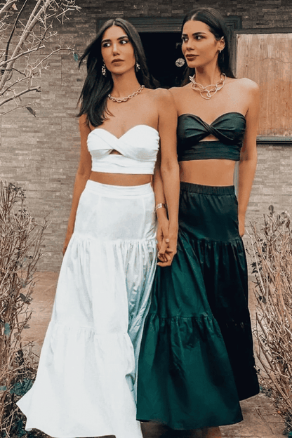 Two women are standing next to each other wearing white and black skirts.